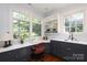 Bright office space featuring custom cabinetry, countertops, and large windows overlooking a lush backyard at 801 Berkeley Ave, Charlotte, NC 28203