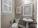 Cozy powder room with pedestal sink, shuttered window, and elegant mirror at 801 Celbridge Ct, Charlotte, NC 28270