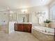 Bright bathroom with a glass shower, soaking tub, vanity with cabinets, and a large mirror at 8618 Whitehawk Hill Rd, Waxhaw, NC 28173