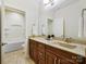 Well-lit bathroom featuring a granite-topped vanity and tiled floor, complemented by a separate toilet and tub space at 8618 Whitehawk Hill Rd, Waxhaw, NC 28173