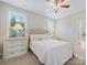 Cozy bedroom featuring a tufted headboard, soft lighting, and a ceiling fan at 8618 Whitehawk Hill Rd, Waxhaw, NC 28173