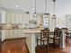 Beautiful kitchen with an island and seating, stylish pendant lighting, stainless appliances and wood floors at 8618 Whitehawk Hill Rd, Waxhaw, NC 28173