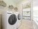 Bright laundry room with modern Samsung washer and dryer, shelving, and a window for natural light at 8618 Whitehawk Hill Rd, Waxhaw, NC 28173