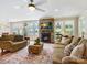 Comfortable living room with a stone fireplace, a ceiling fan and large windows overlooking the backyard at 8618 Whitehawk Hill Rd, Waxhaw, NC 28173