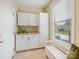 The mudroom features built-in cabinets, a bench, and lots of natural light from the window at 8618 Whitehawk Hill Rd, Waxhaw, NC 28173