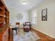 Cozy home office featuring hardwood floors, natural light, and functional built-in shelving at 8618 Whitehawk Hill Rd, Waxhaw, NC 28173