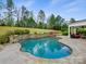 Stunning pool with stone accents, mature trees, and a covered patio area, creating a private retreat at 8618 Whitehawk Hill Rd, Waxhaw, NC 28173