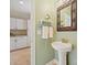 Stylish powder room with a pedestal sink, decorative mirror, and serene paint color at 8618 Whitehawk Hill Rd, Waxhaw, NC 28173