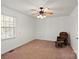 A carpeted bedroom with a ceiling fan, window, and brown rocking chair at 902 Cornelius Rd, Mooresville, NC 28117