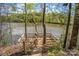 Picturesque lake view from wooded property, featuring a wooden dock, natural landscaping, and calm waters at 902 Cornelius Rd, Mooresville, NC 28117