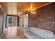 A charming sun room with brick walls, wood paneled ceiling, and a comfortable sofa at 902 Cornelius Rd, Mooresville, NC 28117