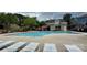 Inviting community pool surrounded by lounge chairs near a charming green building and colorful flowers at 9036 Four Mile Creek Rd, Charlotte, NC 28277