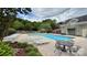 Relaxing community pool surrounded by lounge chairs and lush landscaping near a charming green building at 9036 Four Mile Creek Rd, Charlotte, NC 28277