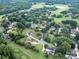 An aerial view shows houses nestled amongst the trees near a golf course and lake in a residential neighborhood at 9427 Bethesda Ct, Matthews, NC 28104
