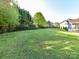 Large grassy backyard with a metal fence and mature trees at 9427 Bethesda Ct, Matthews, NC 28104