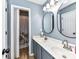 Bright bathroom features a double sink vanity and a shower with floral shower curtain at 9427 Bethesda Ct, Matthews, NC 28104