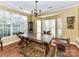 Bright dining room with large windows, stylish light fixture, and unique table design at 9427 Bethesda Ct, Matthews, NC 28104
