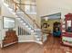 Grand foyer with hardwood floors, staircase with white railings, and decorative furnishings at 9427 Bethesda Ct, Matthews, NC 28104
