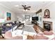 Inviting living room with hardwood floors, a ceiling fan, a decorative fireplace, and lots of natural light at 9427 Bethesda Ct, Matthews, NC 28104
