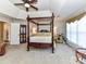 Spacious main bedroom with a decorative ceiling fan and a stately four-poster bed at 9427 Bethesda Ct, Matthews, NC 28104