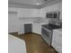 Galley kitchen features stainless steel appliances, white cabinets, and modern fixtures at 9930 Birch Knoll Ct, Charlotte, NC 28213