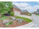 A brick home with a two-car garage, manicured lawn, and lush landscaping, offering great curb appeal at 104 Hallmark Xing, Rock Hill, SC 29732