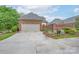 Home exterior with a spacious two-car garage, brick facade, concrete driveway, and manicured landscaping at 104 Hallmark Xing, Rock Hill, SC 29732