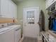 Well-lit laundry room with white cabinets, utility sink, and access door at 104 Hallmark Xing, Rock Hill, SC 29732