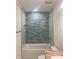 Bathroom with blue subway tile, shower-tub combination, and modern fixtures at 109 Barrett Rd, Cherryville, NC 28021