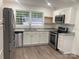 Bright kitchen with stainless steel appliances, granite countertop, white cabinets, and wood floor at 109 Barrett Rd, Cherryville, NC 28021