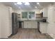 Open kitchen boasts stainless steel appliances, granite countertops, white cabinets, and wood-look flooring at 109 Barrett Rd, Cherryville, NC 28021