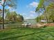 Expansive backyard with lush green lawn, black metal fence, and a private dock leading to the serene lake at 111 Milledge Dr, Mooresville, NC 28117
