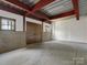 Spacious unfinished basement featuring concrete walls and floors, exposed ceiling beams, and natural light from two windows at 111 Milledge Dr, Mooresville, NC 28117