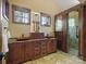 Elegant bathroom featuring double sink vanity with granite countertops, custom wood cabinetry, and a walk-in shower at 111 Milledge Dr, Mooresville, NC 28117