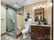 Modern bathroom featuring a glass enclosed shower, granite countertops, and a wooden vanity with decorative wall art at 111 Milledge Dr, Mooresville, NC 28117