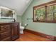 Stylish bathroom features a wooden vanity, an LED mirror, an accent wall, and a window with backyard views at 111 Milledge Dr, Mooresville, NC 28117