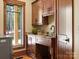 Well-appointed laundry room features wooden cabinetry, granite countertops, and natural light from a large window at 111 Milledge Dr, Mooresville, NC 28117