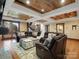Cozy living room features a large sectional sofa, rustic wood ceiling and a view of the lake at 111 Milledge Dr, Mooresville, NC 28117