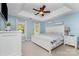 Serene bedroom with a tray ceiling, a ceiling fan, ample natural light, and elegant white furniture at 114 Rolling Stone Ct, Mooresville, NC 28117