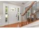 Welcoming entryway with hardwood floors, a decorative front door, and a staircase leading to the upper level at 114 Rolling Stone Ct, Mooresville, NC 28117