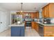 Bright kitchen with wooden cabinets, stainless steel appliances, island with blue base, and modern lighting fixtures at 114 Rolling Stone Ct, Mooresville, NC 28117