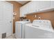 Functional laundry room featuring a side-by-side washer and dryer, with white cabinets providing ample storage above at 114 Rolling Stone Ct, Mooresville, NC 28117