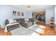 Inviting living room featuring a large sectional sofa, hardwood floors, and a ceiling fan, open to dining area at 114 Rolling Stone Ct, Mooresville, NC 28117
