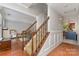 Foyer featuring a staircase with wood railing, carpeted steps, and decorative trim, leading to the second floor at 114 Rolling Stone Ct, Mooresville, NC 28117