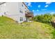 A backyard with a concrete patio and a small wooden deck above, surrounded by lush greenery and a black fence at 12305 Stinson Ct, Charlotte, NC 28277