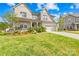 Charming two-story home with a well-manicured lawn, beautiful landscaping, and inviting front porch at 12305 Stinson Ct, Charlotte, NC 28277