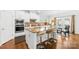 Modern kitchen with white cabinets, stainless steel appliances, and an island with bar stool seating at 12305 Stinson Ct, Charlotte, NC 28277