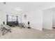 Bright living room with comfy chairs, a dark sofa, large window, and neutral carpet flooring at 12305 Stinson Ct, Charlotte, NC 28277