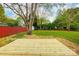 Backyard with a wood deck, trees, and red fence at 13417 Krislyn Woods Pl, Charlotte, NC 28278