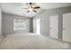 Neutral bedroom with bright light has a ceiling fan and attached bathroom at 13417 Krislyn Woods Pl, Charlotte, NC 28278